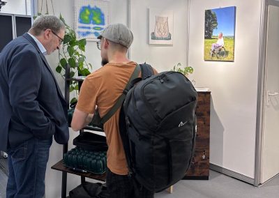 Beratung am CONFORM-Stand, Besucher sehen sich die Sitzkissen an